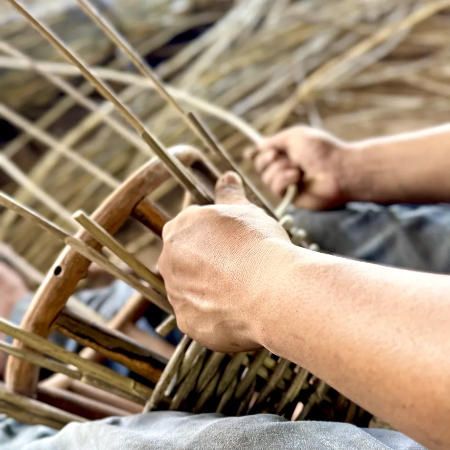 Eurochair artisan hands weaving a rattan chair frame